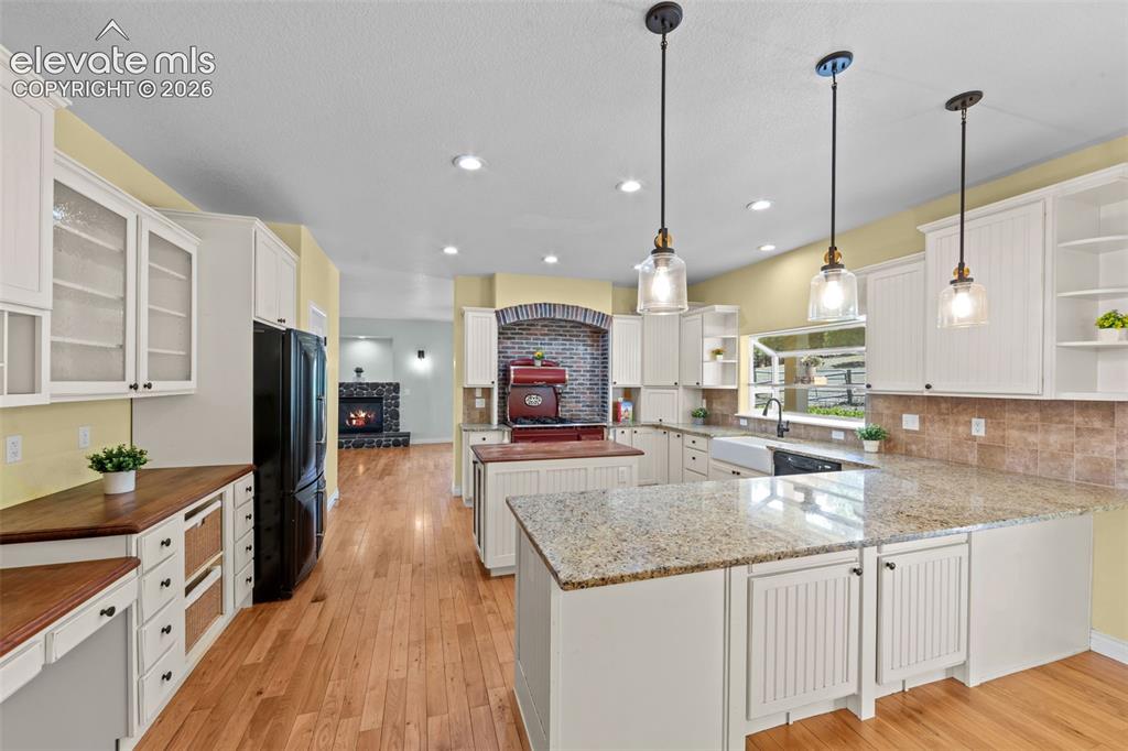 16540 Mesquite Road Peyton, CO 80831 - Photo 11 of 50 a kitchen with kitchen island granite countertop a sink a counter top space appliances and cabinets