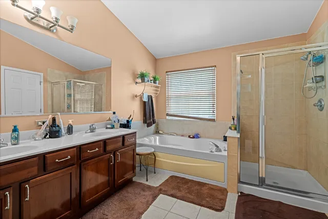 a spacious bathroom with a tub sink shower and mirror