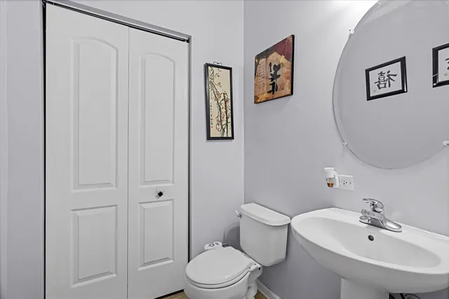 a bathroom with a toilet a sink and mirror