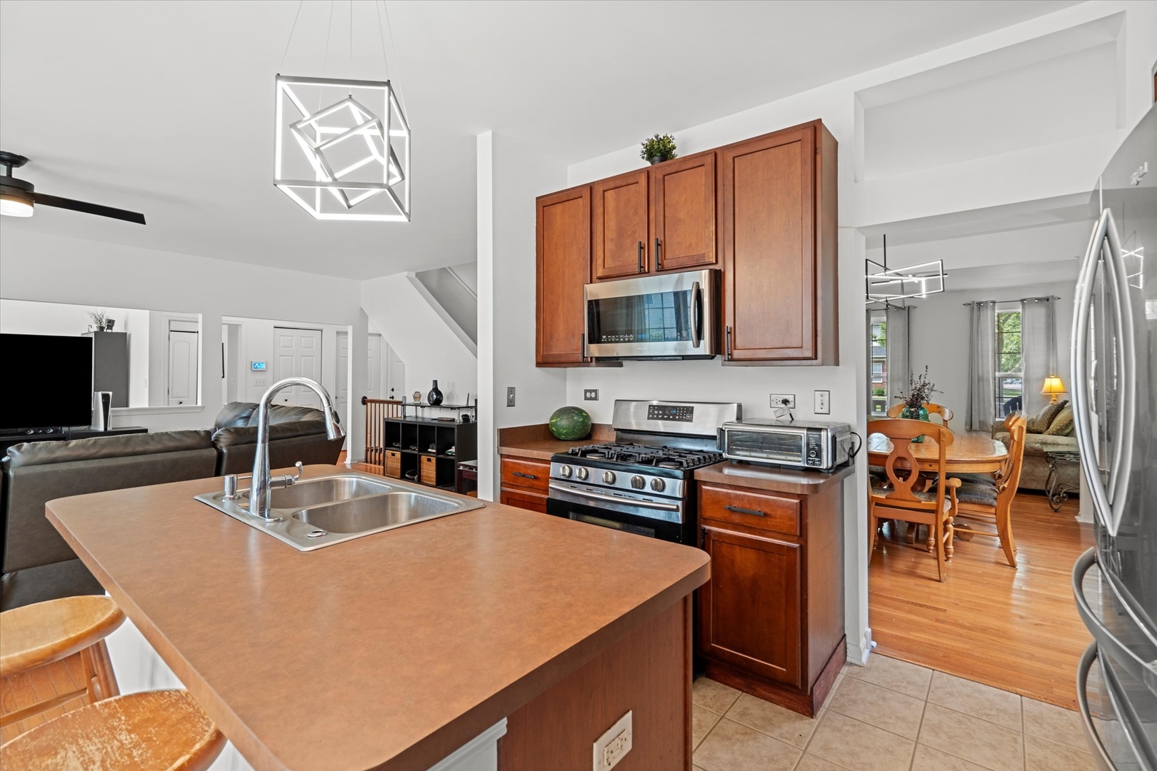 1314 Danhof Drive Bolingbrook, IL 60490 - Photo 6 of 39 a kitchen with stainless steel appliances granite countertop a stove top oven a sink a dining table and chairs with wooden floor
