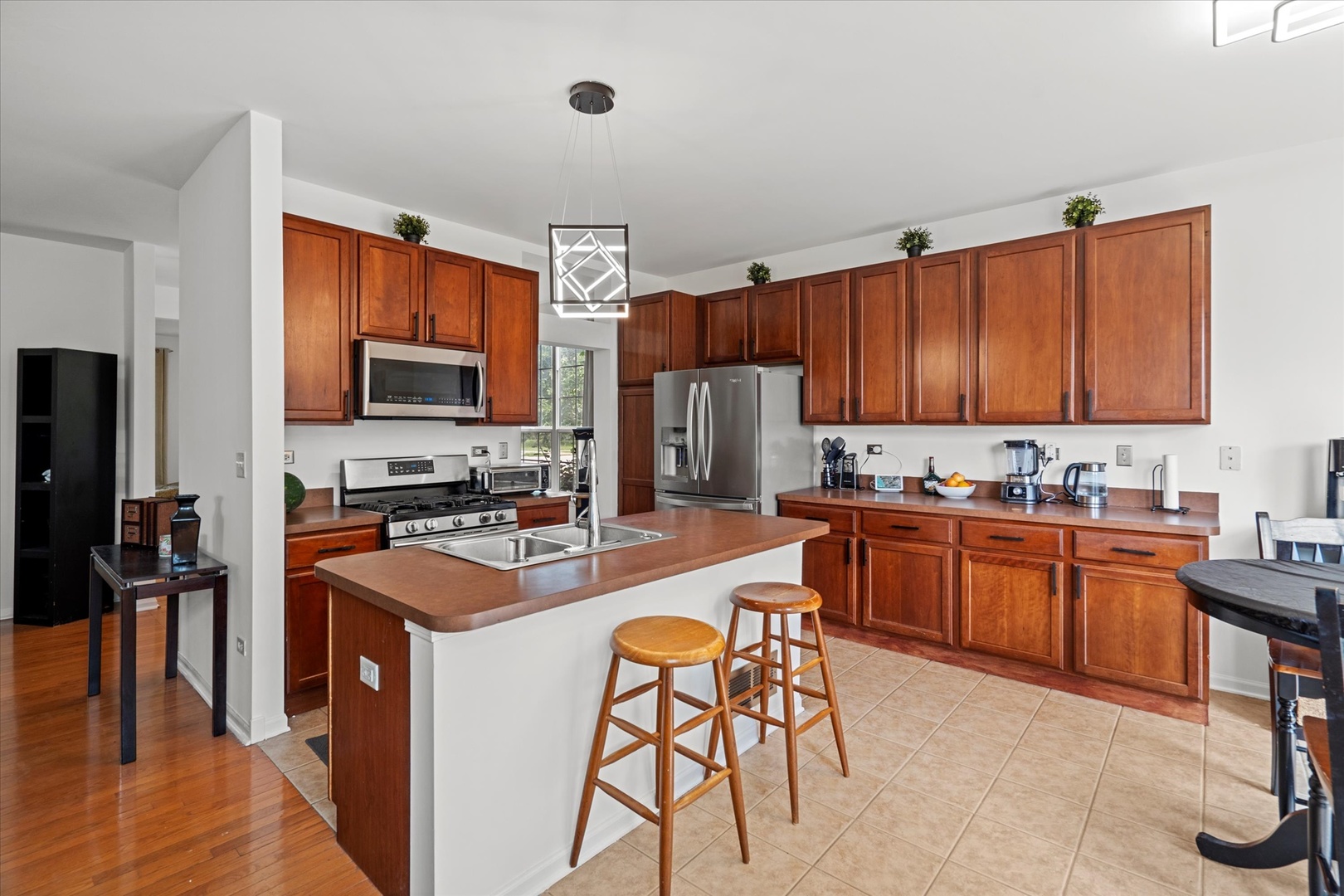 1314 Danhof Drive Bolingbrook, IL 60490 - Photo 7 of 39 a kitchen with stainless steel appliances granite countertop a stove top oven a sink dishwasher a dining table and chairs with wooden floor