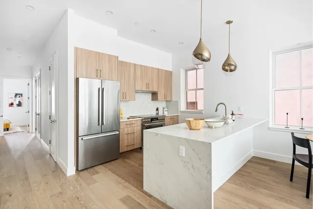 a kitchen with a stove a sink a dining table and chairs