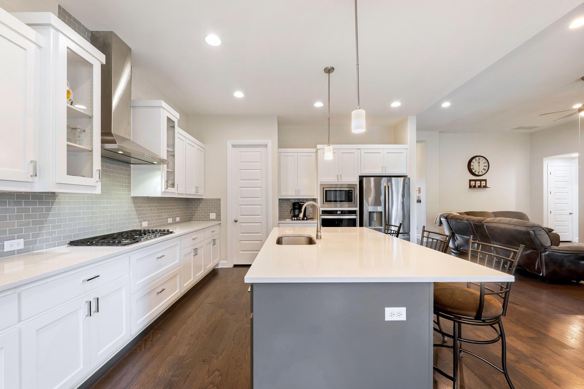 1009 Legacy Crossing Georgetown, TX 78628 - Photo 17 of 40 Culinary aspirations come alive in this kitchen, featuring an expansive island, sleek stainless appliances, and warm wood flooring.