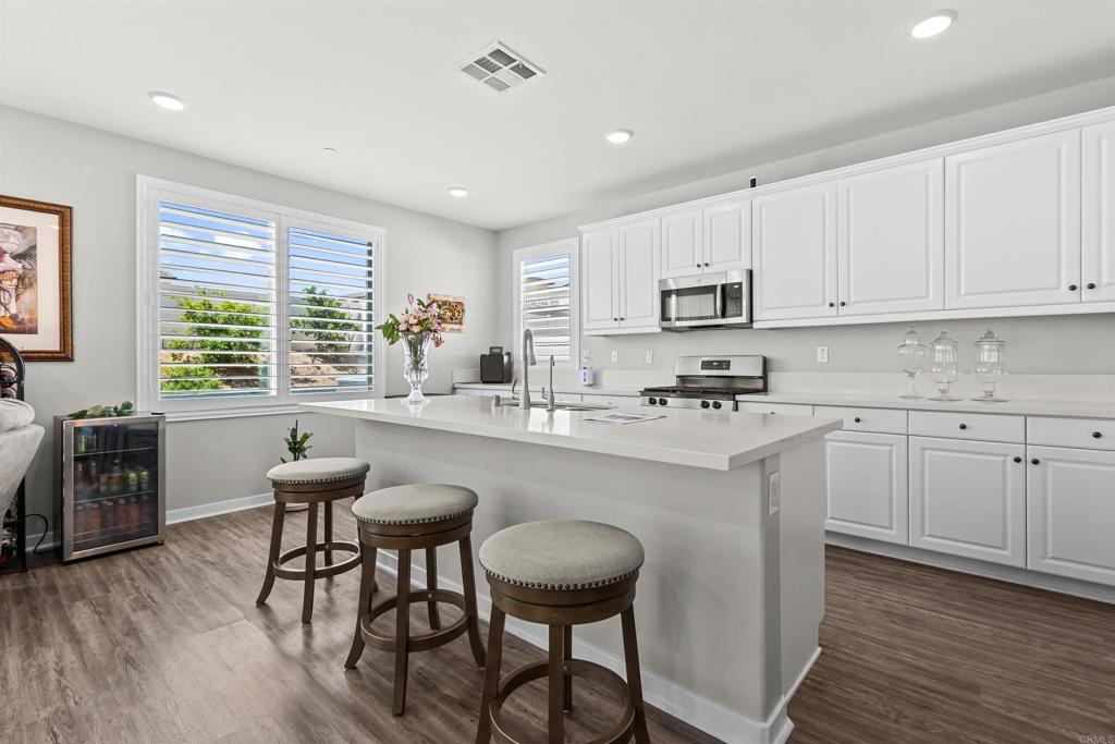 29809 Gypsy Vanner Way Menifee, CA 92584 - Photo 18 of 45 a kitchen with stainless steel appliances granite countertop a table chairs sink refrigerator and cabinets