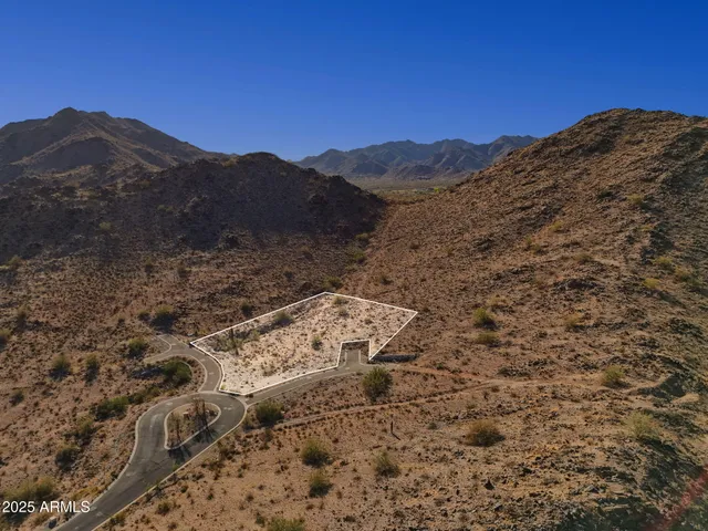 a view of a dry yard with mountains in the background