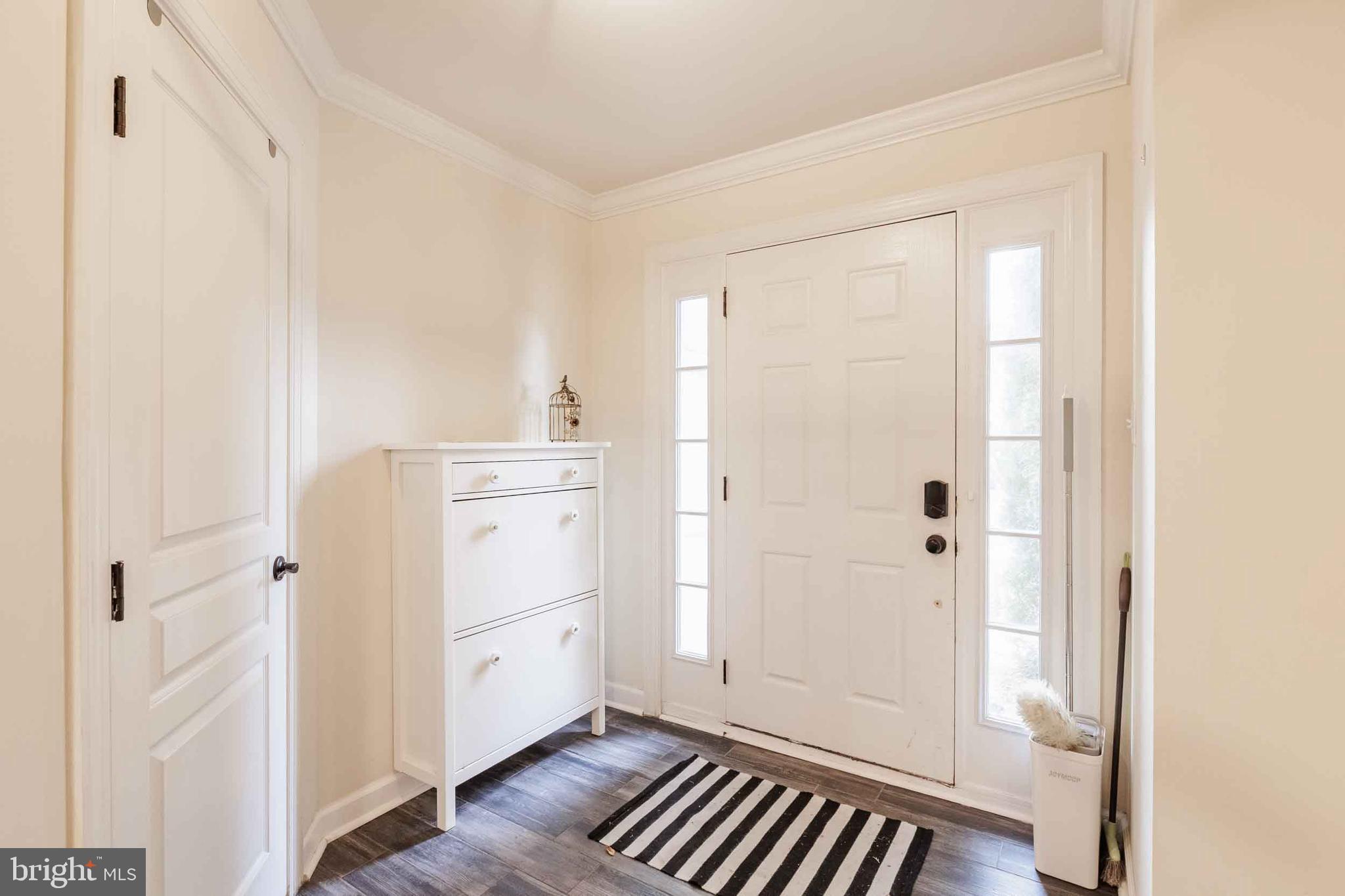 9733 Braidwood Terrace Frederick, MD 21704 - Photo 3 of 33 a view of a kitchen with white cabinets and wooden floor