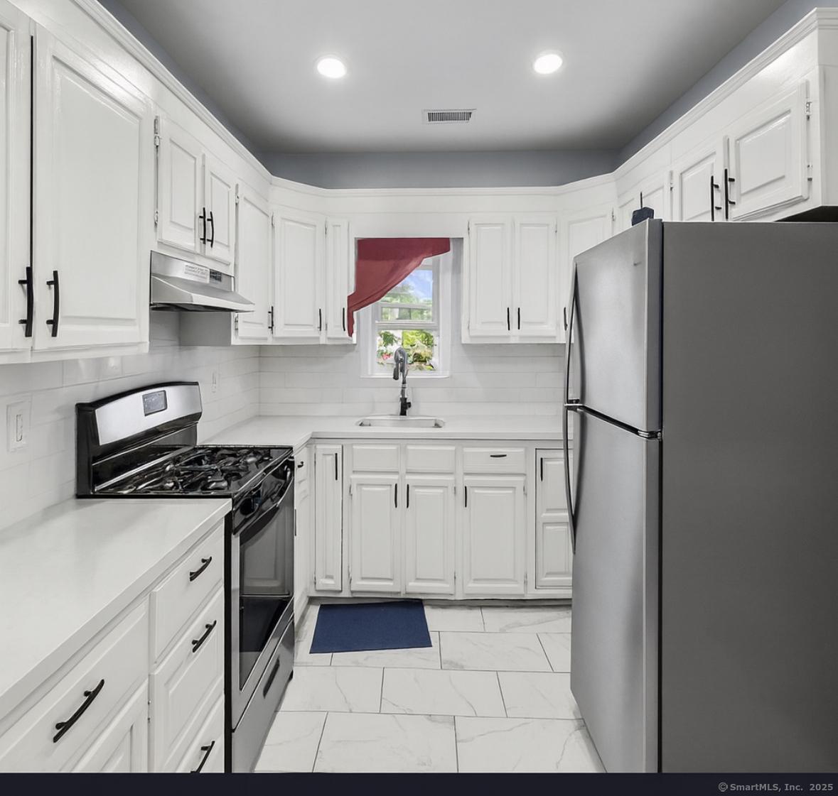 a kitchen with stainless steel appliances granite countertop a refrigerator sink and stove