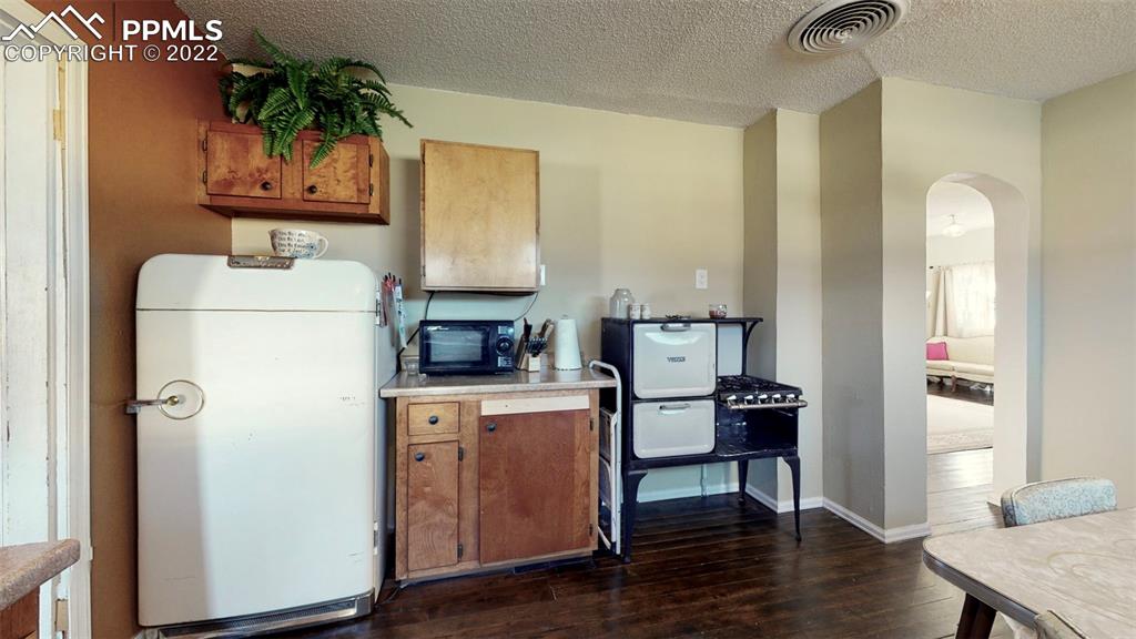 211 West 3rd Street Walsenburg, CO 81089 - Photo 11 of 33 a kitchen with a refrigerator and a stove top oven