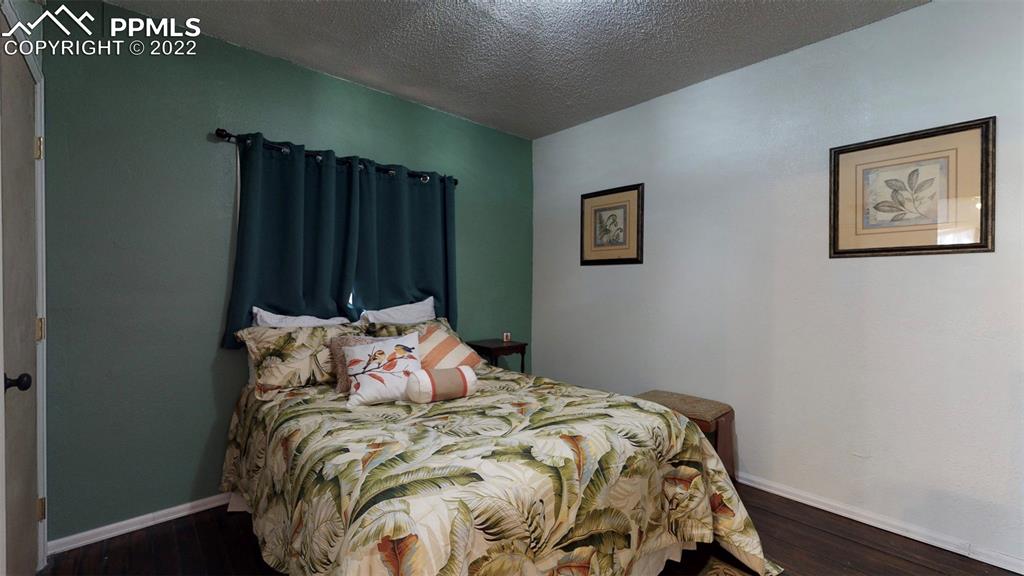 211 West 3rd Street Walsenburg, CO 81089 - Photo 23 of 33 a bed sitting in a bedroom next to a small yard