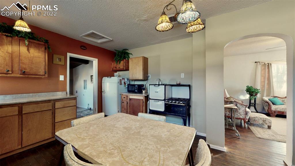 211 West 3rd Street Walsenburg, CO 81089 - Photo 9 of 33 a kitchen with kitchen island stainless steel appliances a stove refrigerator dining table and chairs