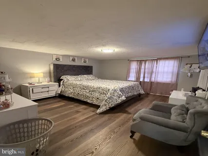 a bedroom with a bed couch and window