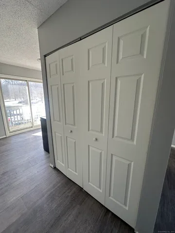 a view of an empty room with wooden floor and a fireplace