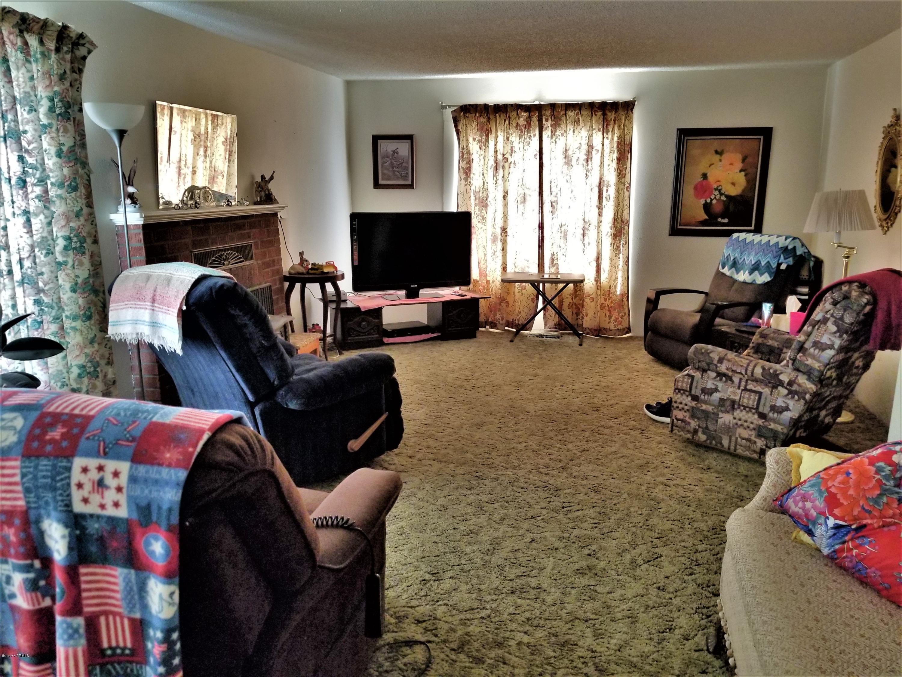 1900 Liberty Road Granger, WA 98932 - Photo 2 of 12 a living room with furniture a window and a flat screen tv