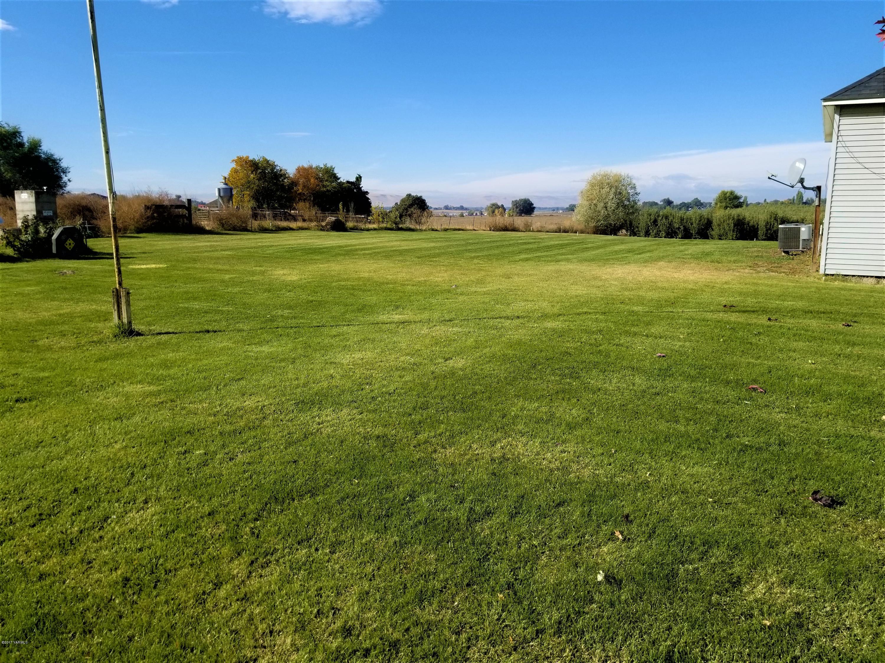 1900 Liberty Road Granger, WA 98932 - Photo 6 of 12 a view of a grassy field with an trees