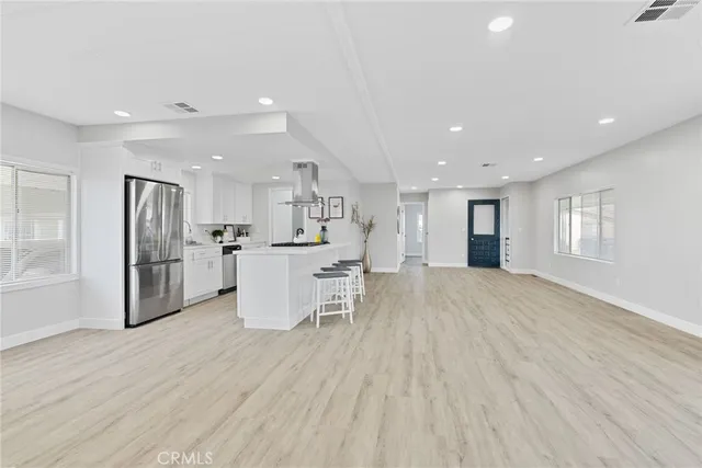 a view of kitchen dining table wooden floor and stainless steel appliances