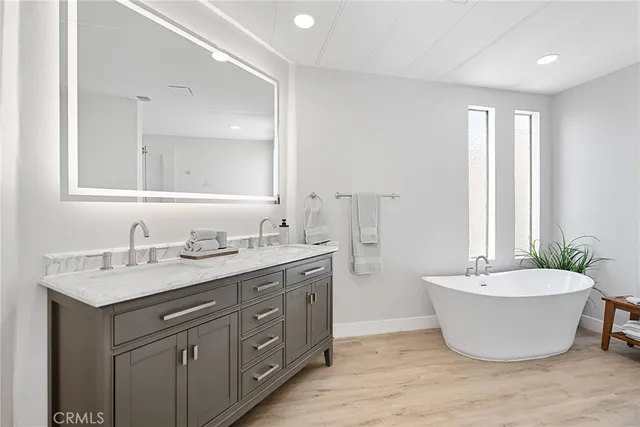 a spacious bathroom with a double vanity sink mirror and bathtub