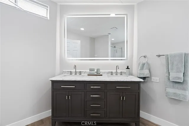 a bathroom with a granite countertop sink and a mirror