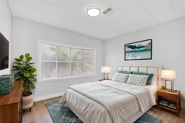 a bedroom with a large bed and a potted plant