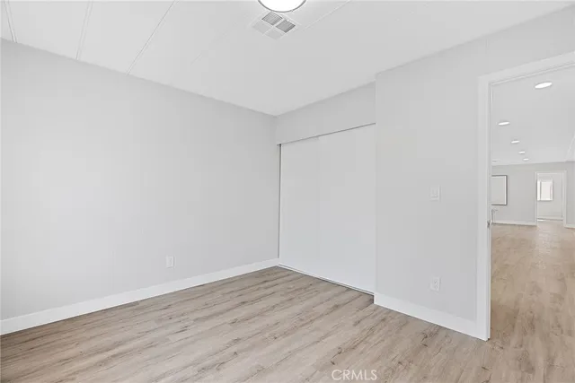 a view of a room with wooden floor and a ceiling fan