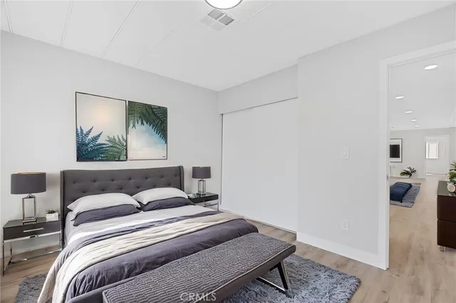 a bedroom with a bed and wooden floor