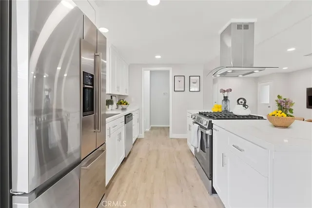 a kitchen with stainless steel appliances a sink stove and refrigerator