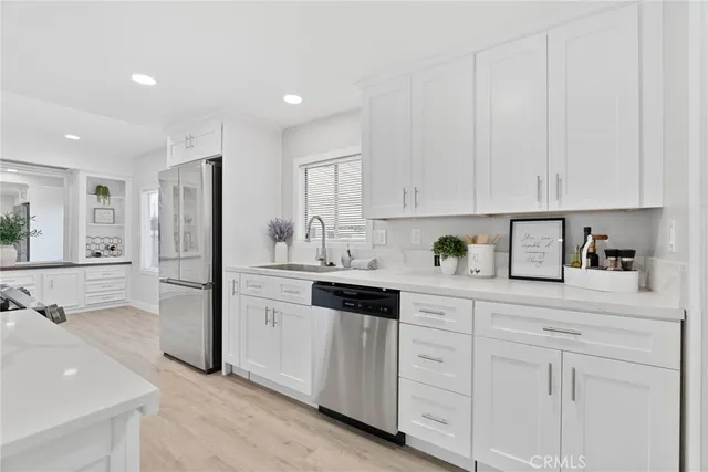 a kitchen with white cabinets and stainless steel appliances