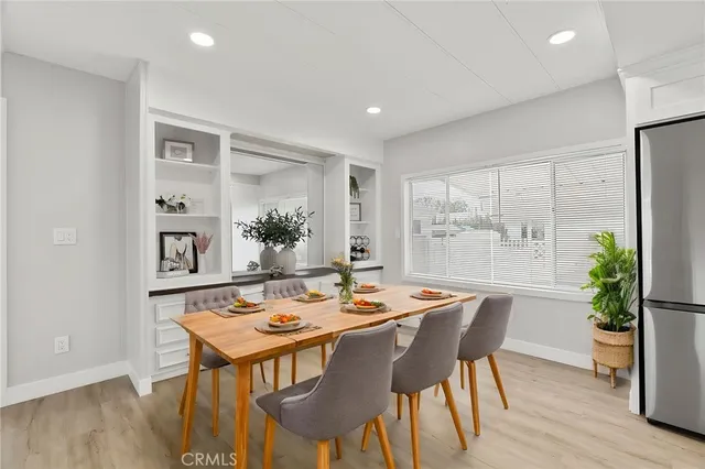 a dining room with furniture potted plants and wooden floor