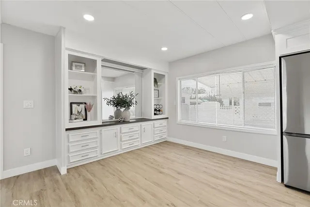 a large kitchen with a lot of wooden floor and stainless steel appliances