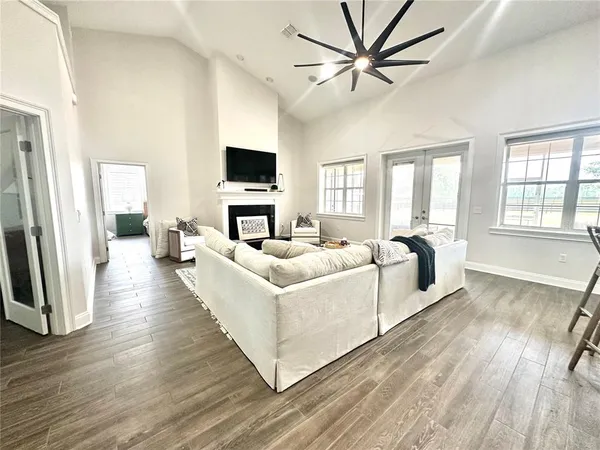 a living room with stainless steel appliances kitchen island a flat screen tv and a refrigerator