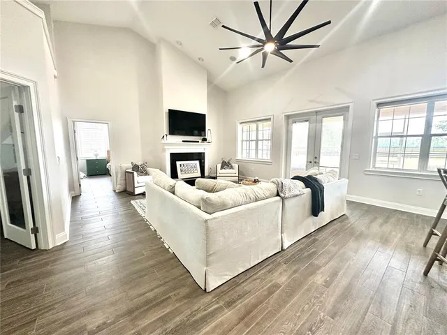 a living room with stainless steel appliances kitchen island a flat screen tv and a refrigerator