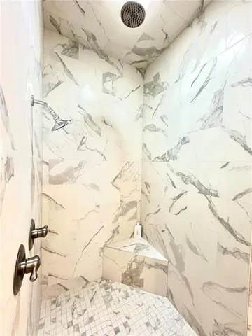 a bedroom with a large bed chandelier and a window