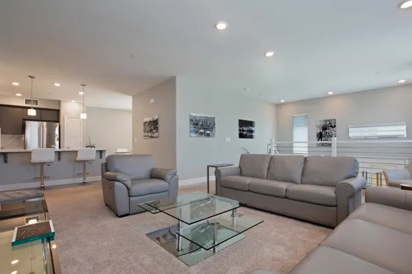 a living room with furniture and a view of kitchen