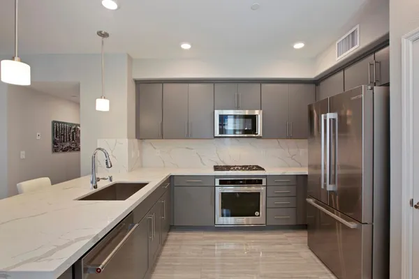 a kitchen with stainless steel appliances a sink stove and refrigerator