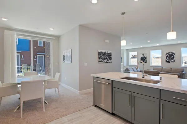 a room with a sink dishwasher a dining table and chairs with wooden floor