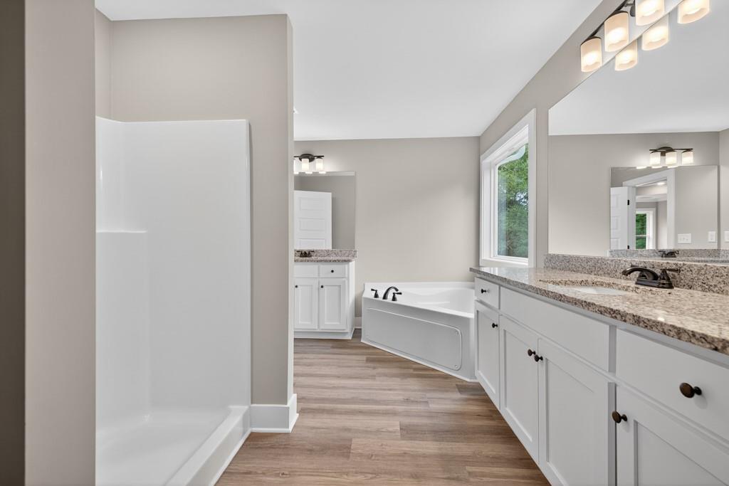328 Advent Drive Winder, GA 30680 - Photo 22 of 45 a large bathroom with a granite countertop double vanity sink a mirror and a bathtub