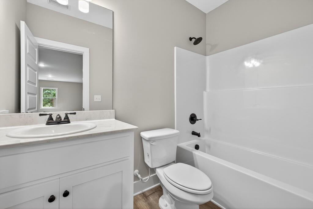 328 Advent Drive Winder, GA 30680 - Photo 40 of 45 a bathroom with a toilet a sink a mirror a bathtub and vanity