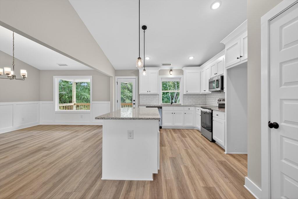 328 Advent Drive Winder, GA 30680 - Photo 10 of 45 a kitchen with stainless steel appliances a refrigerator a sink dishwasher a stove and white countertops with wooden floor