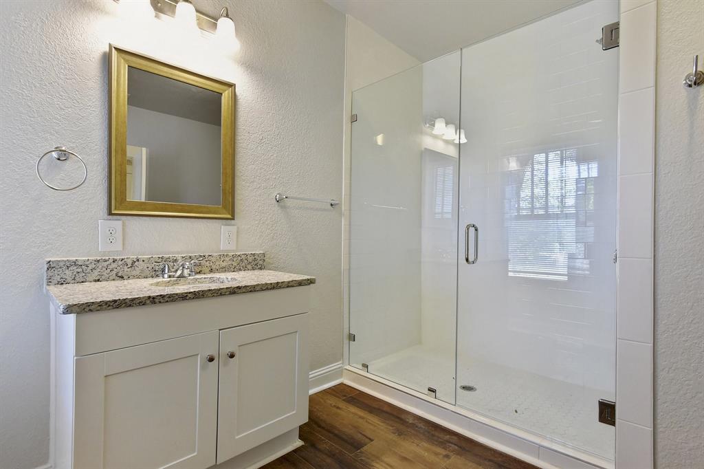 1115 South Rusk Avenue Denison, TX 75020 - Photo 16 of 21 a bathroom with a granite countertop sink mirror and shower