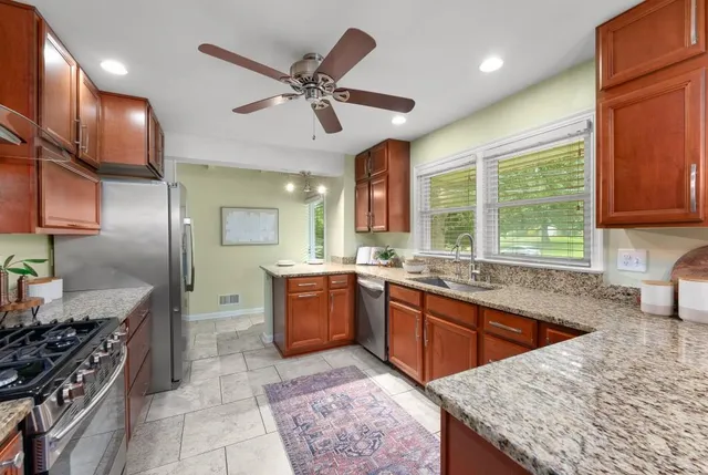 a kitchen with stainless steel appliances granite countertop a sink stove and refrigerator