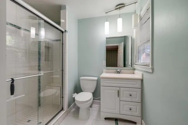 a bathroom with a toilet a sink and mirror