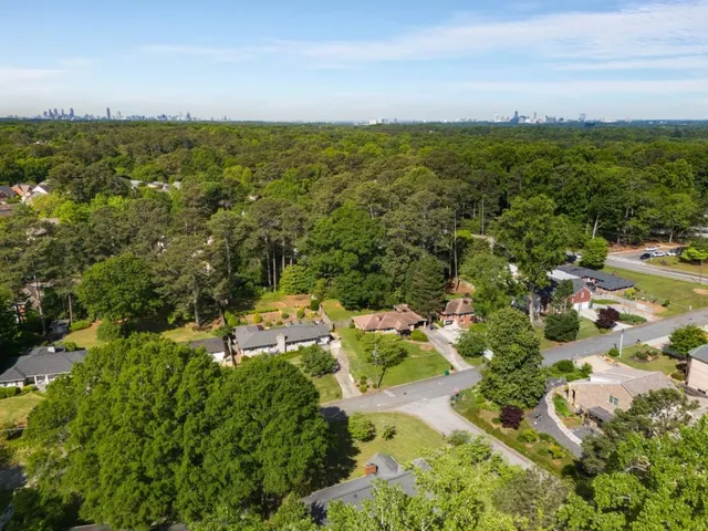 an aerial view of residential houses with outdoor space and trees