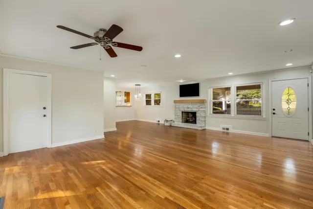 a view of empty room with wooden floor and window