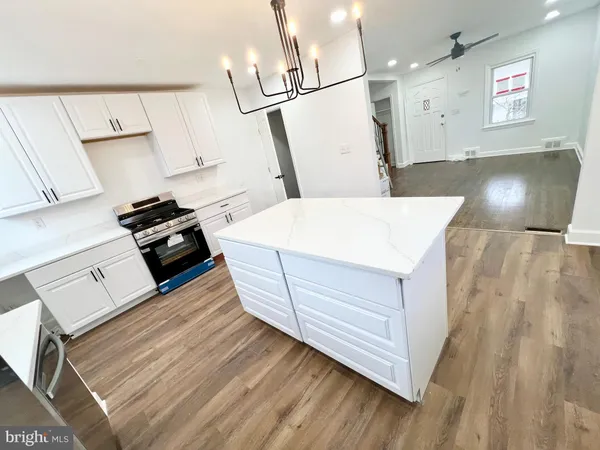 a large kitchen with kitchen island a sink stainless steel appliances and cabinets