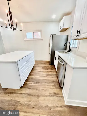a kitchen with stainless steel appliances white cabinets a sink a stove a refrigerator and white cabinets