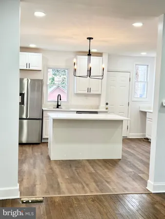 an empty room with wooden floor ceiling fan and windows
