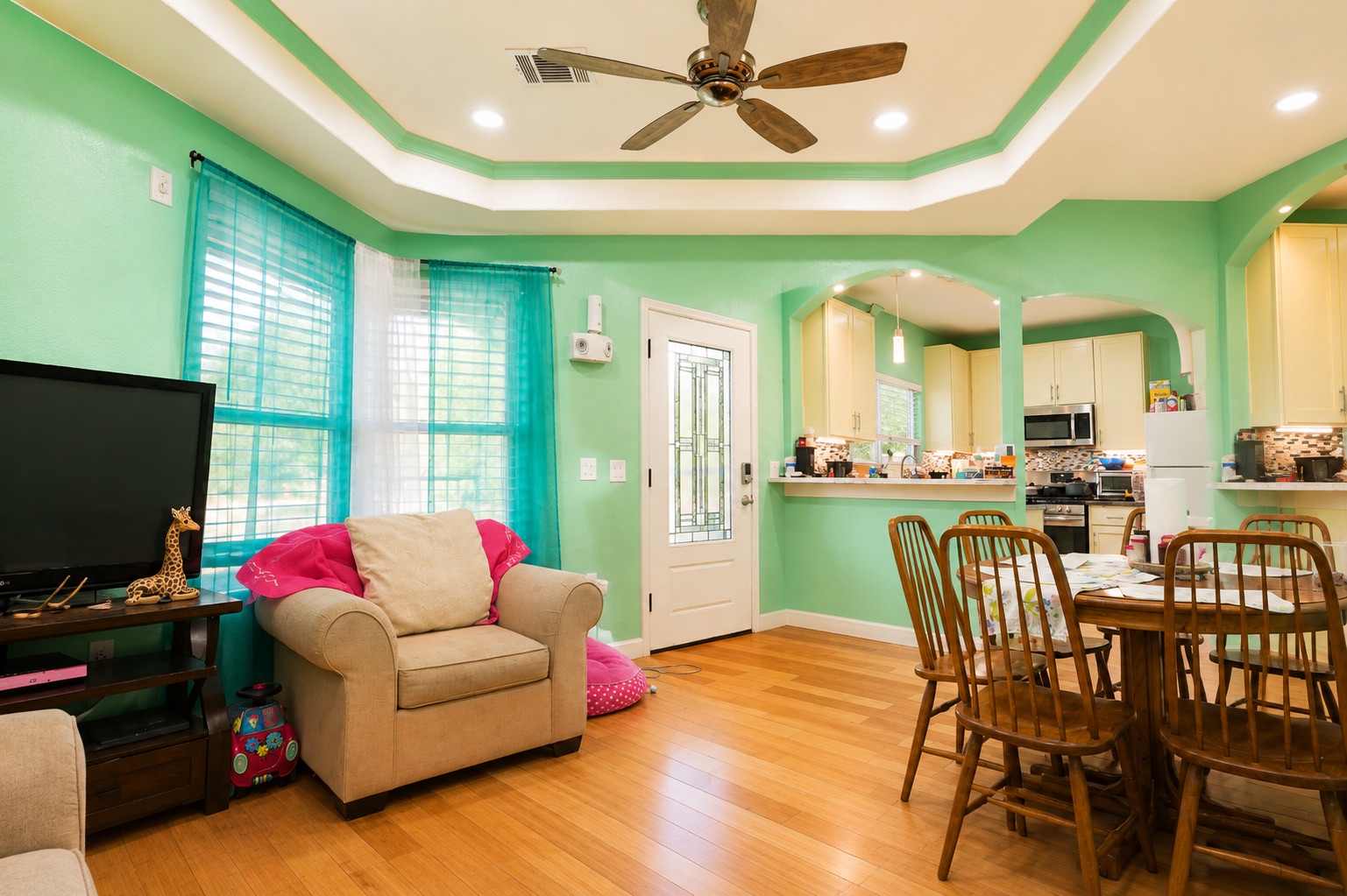 130 Los Arcos Road Elgin, TX 78621 - Photo 17 of 39 Hardwood floors flow through this sun-drenched living area, featuring a decorative ceiling and recessed lighting.