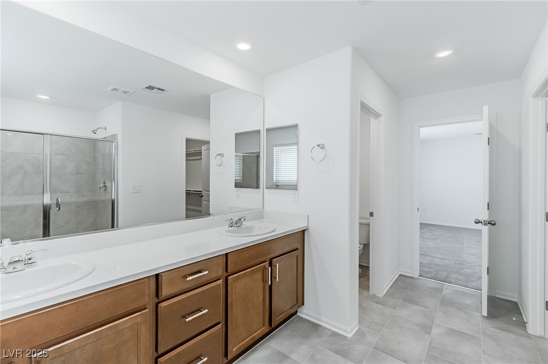 7859 Lacemaker Court Las Vegas, NV 89113 - Photo 11 of 24 Full bath featuring double vanity, a stall shower, recessed lighting, a walk in closet, and light tile patterned floors