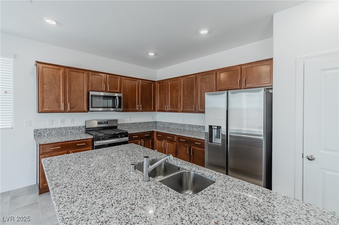 7859 Lacemaker Court Las Vegas, NV 89113 - Photo 5 of 24 Kitchen with appliances with stainless steel finishes, light stone counters, recessed lighting, and light tile patterned floors