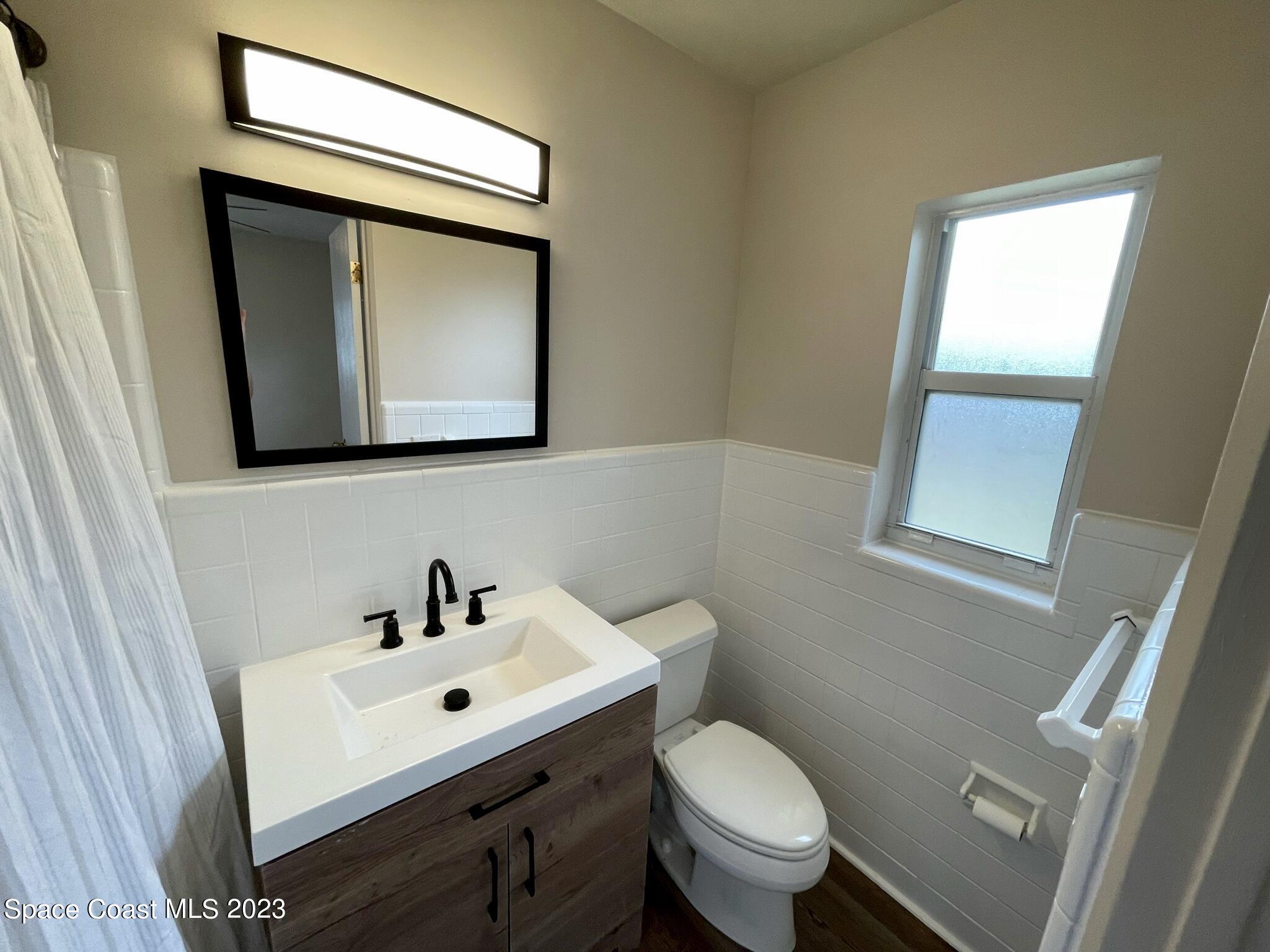 1820 Harrison Avenue Melbourne, FL 32935 - Photo 13 of 20 a bathroom with a toilet sink and mirror