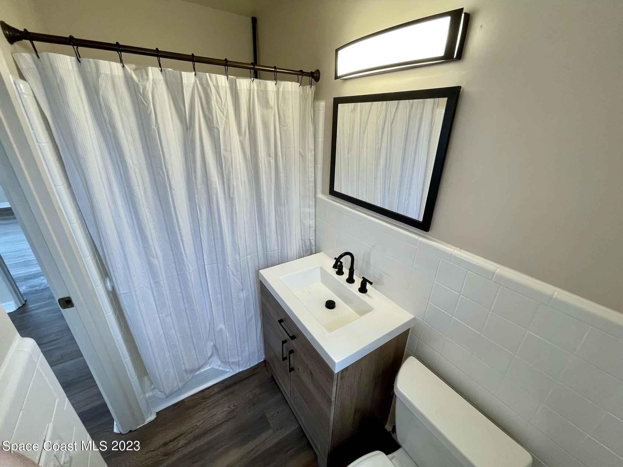 1820 Harrison Avenue Melbourne, FL 32935 - Photo 14 of 20 a bathroom with a sink a mirror and vanity